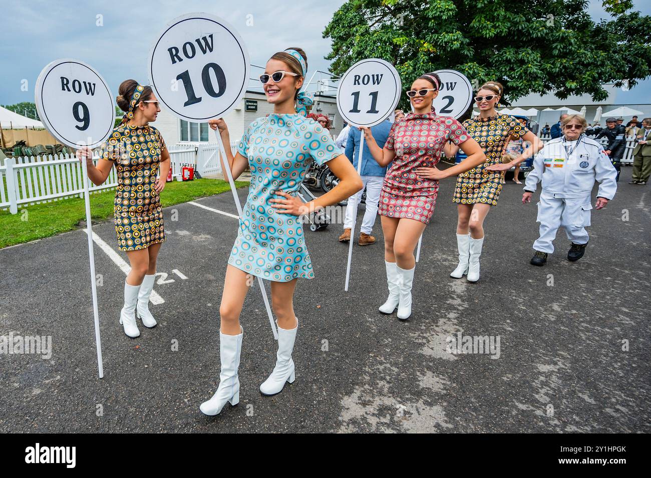 Goodwood, Regno Unito. 7 settembre 2024. Le ragazze lellipop, in minigonne vintage, segnano le posizioni di partenza in griglia mentre i piloti si preparano per la gara motociclistica Barry Sheene Memorial Trophy, nell'area di montaggio - la rinascita Goodwood - l'unico meeting storico di gare motoristiche ad essere messo in scena interamente in un tema d'epoca, una coinvolgente celebrazione di auto e moda iconiche. Crediti: Guy Bell/Alamy Live News Foto Stock