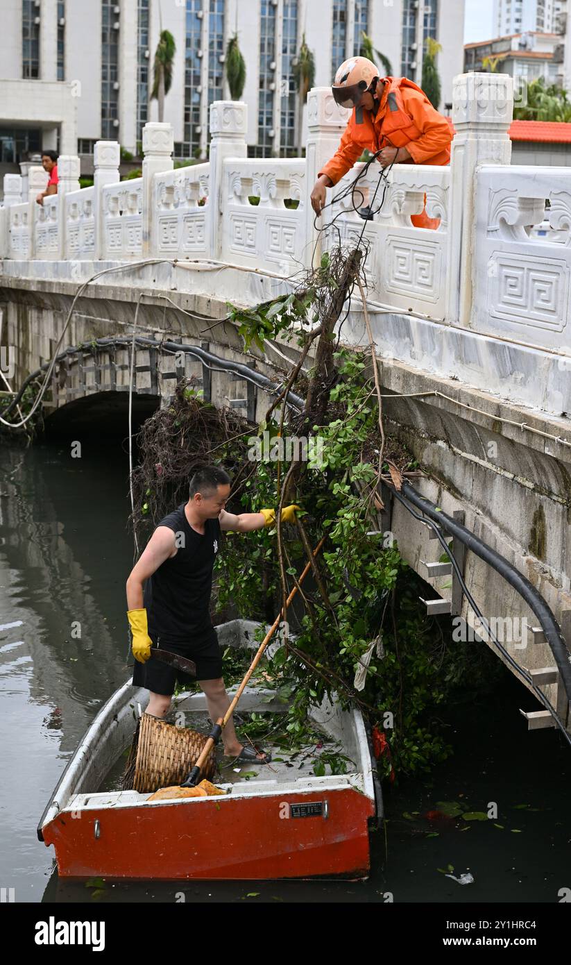 Haikou, la provincia cinese di Hainan. 7 settembre 2024. I lavoratori rimuovono i rami caduti su un fiume a Haikou, nella provincia cinese meridionale di Hainan, 7 settembre 2024. Il Super Typhoon Yagi ha colpito la provincia dell'isola di Hainan, nella Cina meridionale, con forti piogge e venti gustosi, lasciando almeno due persone morte e 92 feriti, hanno detto le autorità locali sabato. Quando venti e piogge si placarono, Hainan diminuì il suo allarme tifone e avviò rapide operazioni di recupero in tutta la provincia. Crediti: Guo Cheng/Xinhua/Alamy Live News Foto Stock