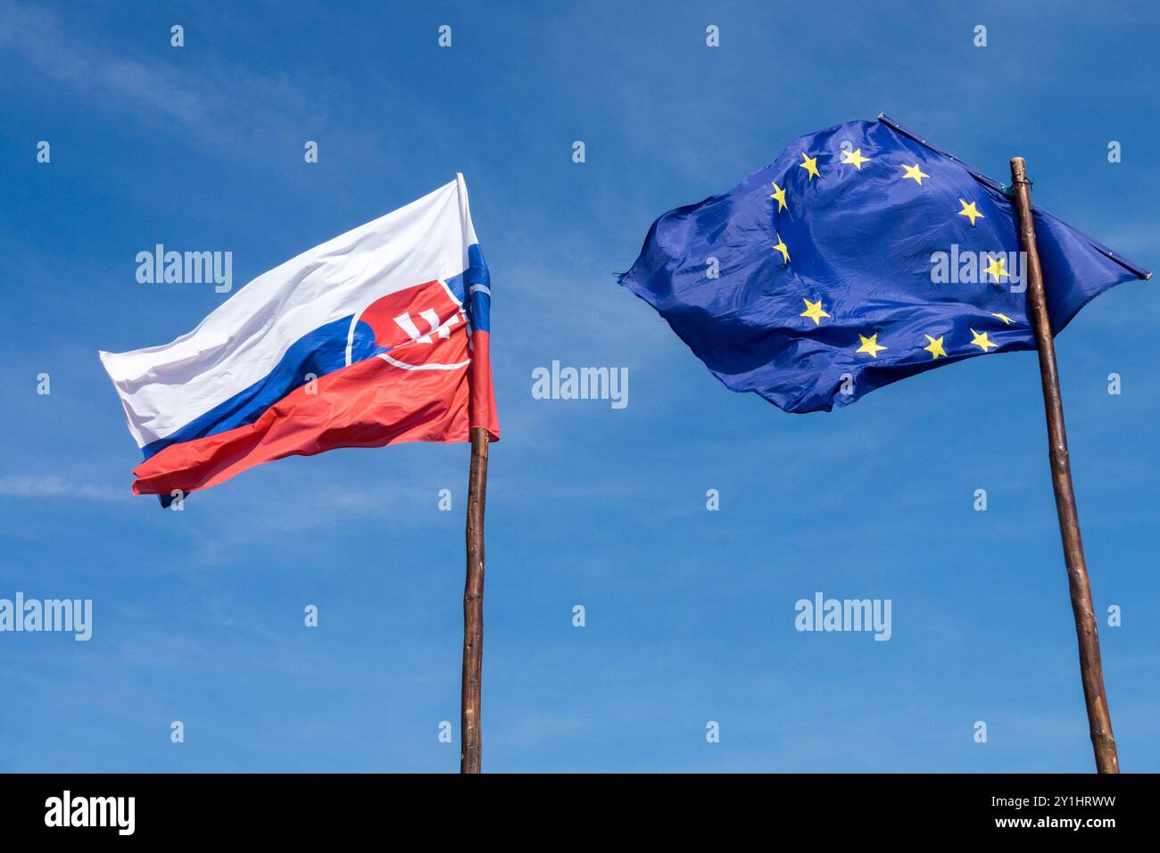 Bandiera della Slovacchia e bandiera dell'Unione europea che soffia nel vento su bandiere di legno bandiere Slovensko Foto Stock