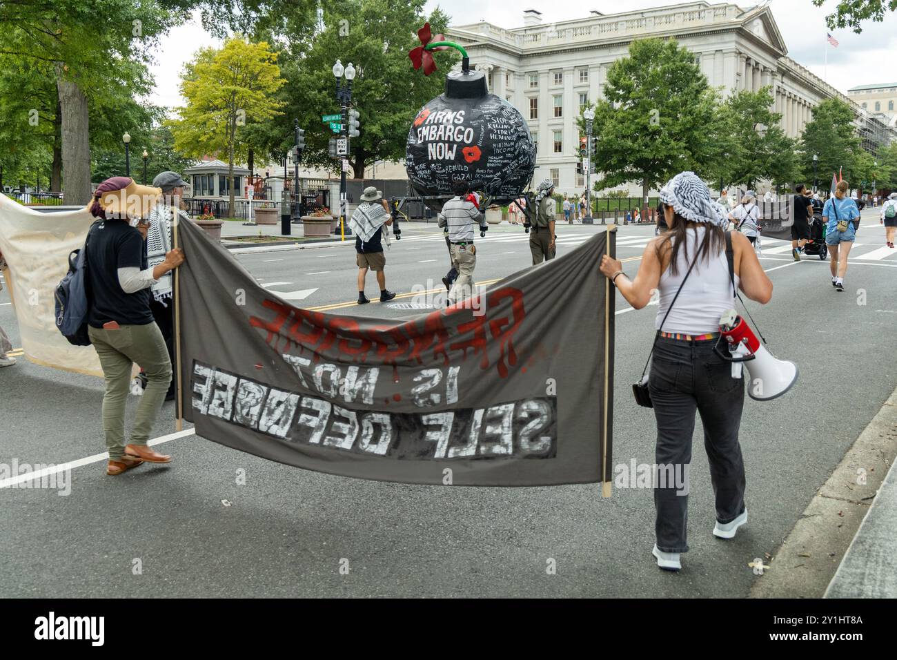 Washington DC, USA - 19/08/2024: Un gruppo di manifestanti sta marciando per strada con uno striscione che dice "il genocidio non è autodifesa” Foto Stock Washington DC, USA - 19/08/2024: Un gruppo di manifestanti sta marciando per strada con uno striscione che dice "il genocidio non è autodifesa” Foto Stock