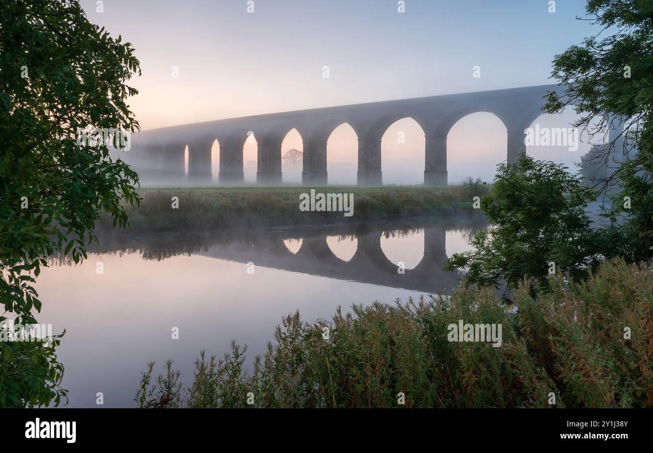 I toni pastello pre-alba donano una sensazione di calma al paesaggio che circonda il viadotto di Arthington in una placida mattinata d'estate. Foto Stock