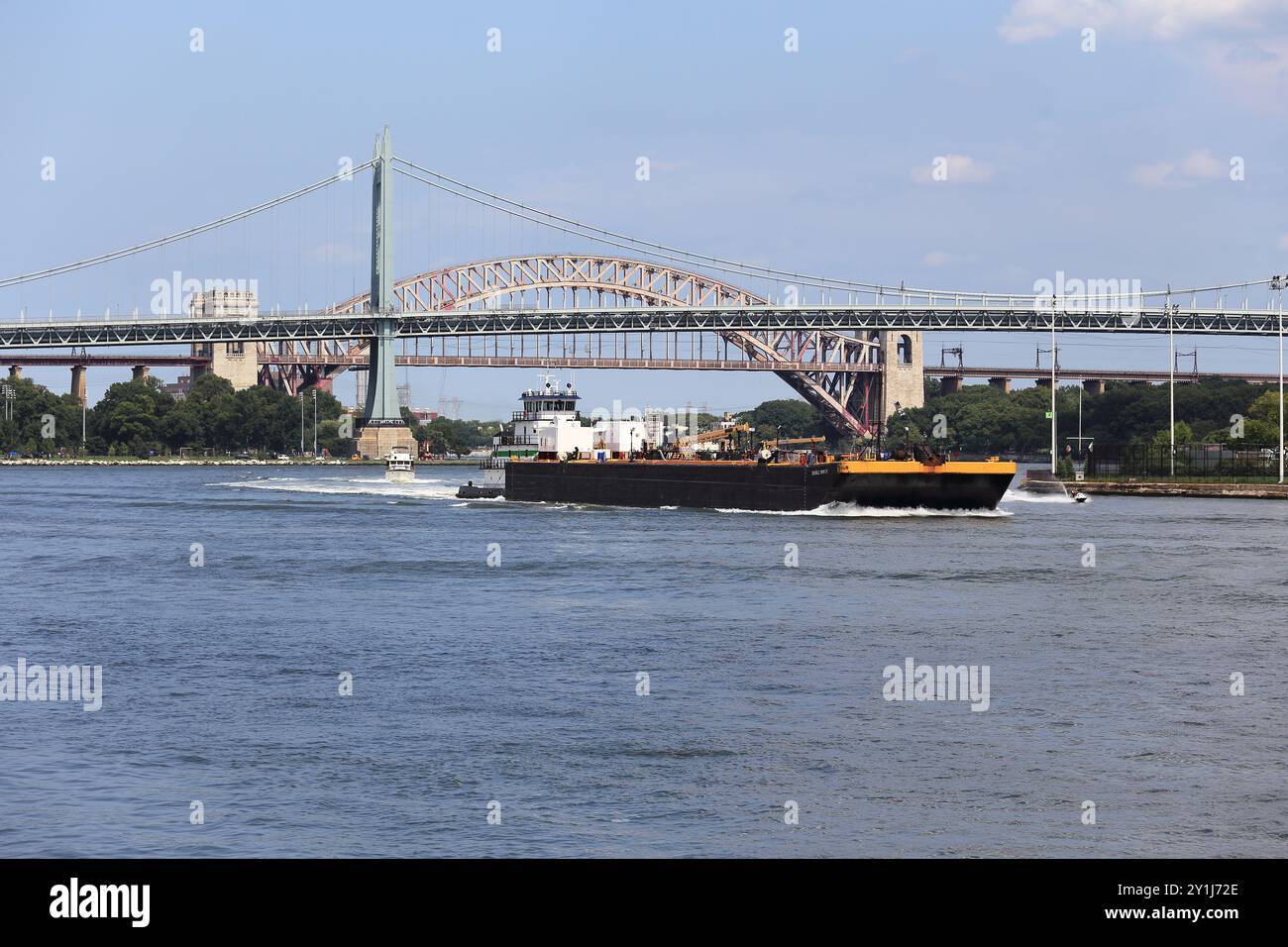 Tugboat che spinge la chiatta attraverso la pericolosa sezione Hell Gate dell'East River nel Queens, New York City Foto Stock