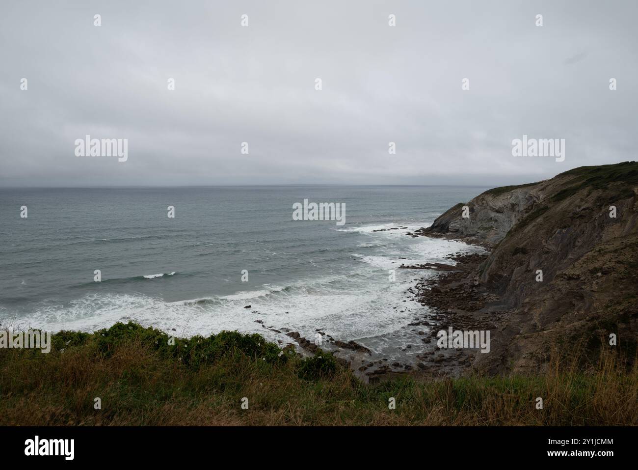 Il flysch vicino a Bilbao, nei Paesi baschi (Spagna). Foto scattata subito dopo la pioggia, con mare agitato in una giornata ventosa. Foto Stock