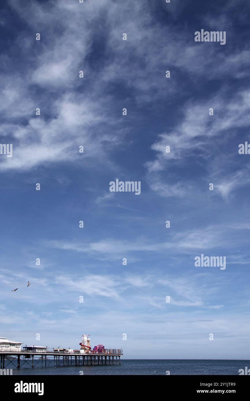 Molo sul mare britannico in un mare calmo sotto il cielo blu estivo Foto Stock