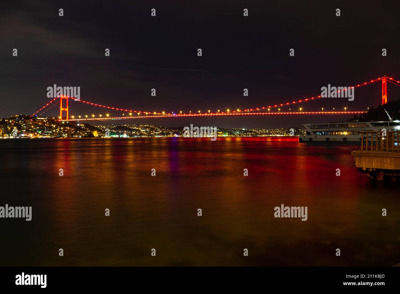 Ponte sospeso illuminato per la notte che riflette il bagliore urbano di ıstanbul, turchia Foto Stock