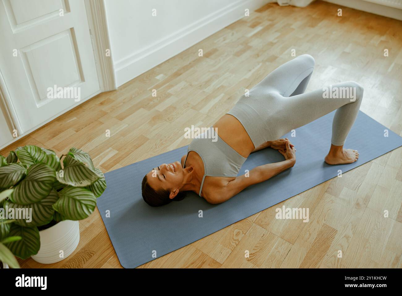 Praticare lo yoga in un ambiente interno sereno con particolare attenzione allo sviluppo della flessibilità Foto Stock