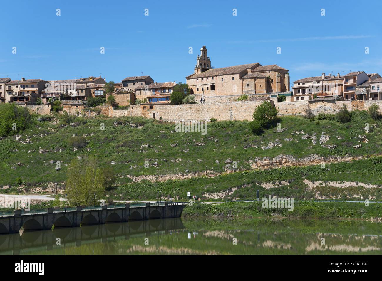 Città storica con chiesa su una collina sopra un fiume con un ponte di pietra, l'acqua riflette il paesaggio, Maderuelo, Rio Riaza, fiume Riaza, Embalse d'Embalse Foto Stock