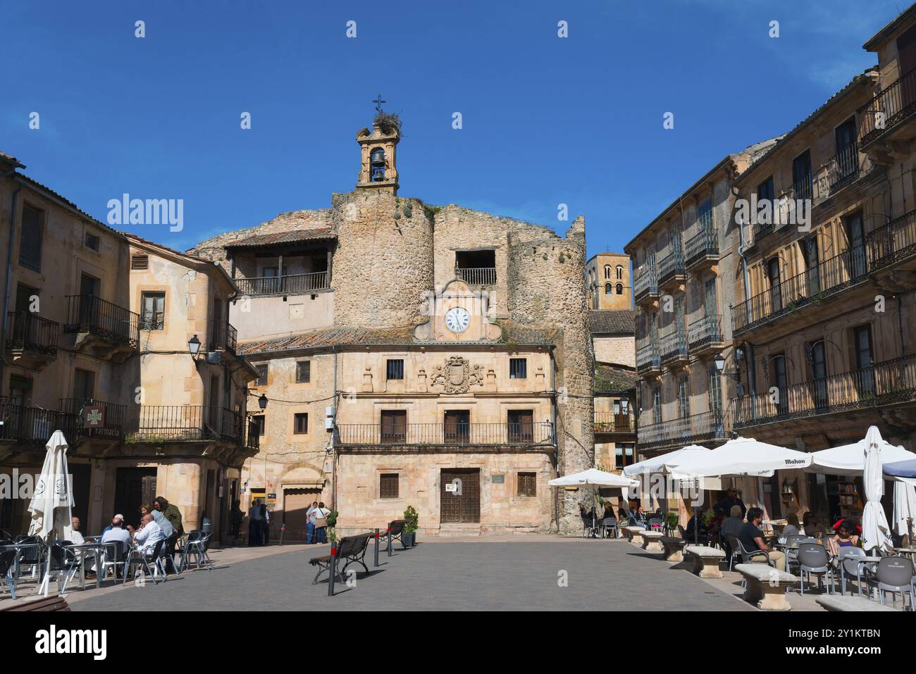 Piazza storica con muri in pietra, caffetterie e ombrelloni, affollata di gente e dominata da una torre dell'orologio, Castillo, vecchia fortezza del castello, Plaza de es Foto Stock