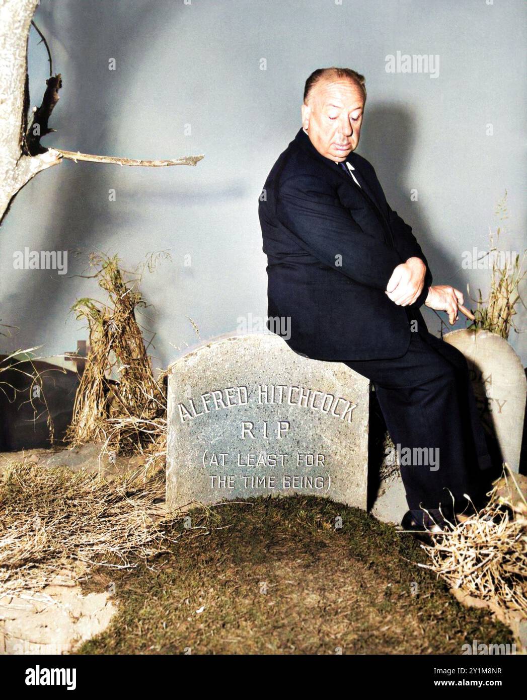 1960 c. , USA : il celebre regista ALFRED HITCHCOCK ( 1899 - 1980 ), pubblicitario ancora per l'uscita pubblicitaria di TV Serial ALFRED HITCHOCH PRESENTS ( CBS TV , 1955 - 1962 ). In ogni episodio Hitchcock apparve all'inizio come presentatore per introdurre la trama dell'episodio e poi ricomparve alla fine mettendo una lucentezza con una conclusione 'morale' in modo assurdo, macabro, divertente e totalmente surreale come nel suo stile. La foto lo ritrae in uno di questi momenti seduto su una lapide sulla quale appare la scritta "ALFRED HITCHCOCK R.I.P. ( ALMENO PER IL MOMENTO )". Non disponibile Foto Stock