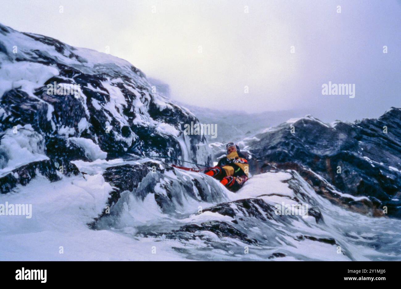 Øyvind Martinsen sta risalendo una parte ripida e ghiacciata in una salita invernale nel Troll Wall verticale di 3000 metri nella valle di Romsdalen, Rauma kommune, Møre og Romsdal, Norvegia. Febbraio 1992. Foto Stock