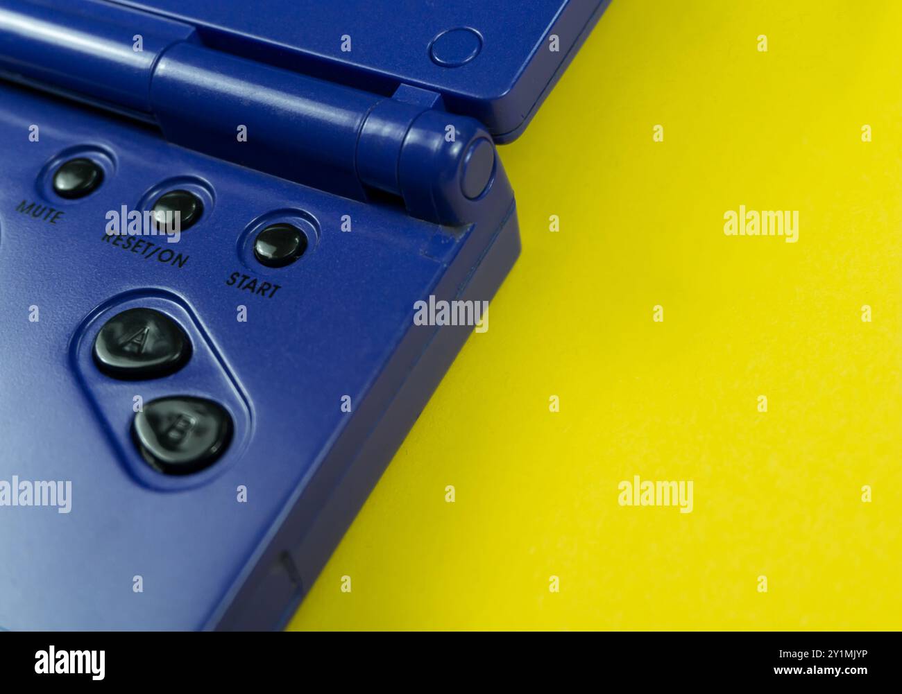 Controller di gioco vintage con tasti direzionali e di selezione su sfondo giallo brillante Foto Stock
