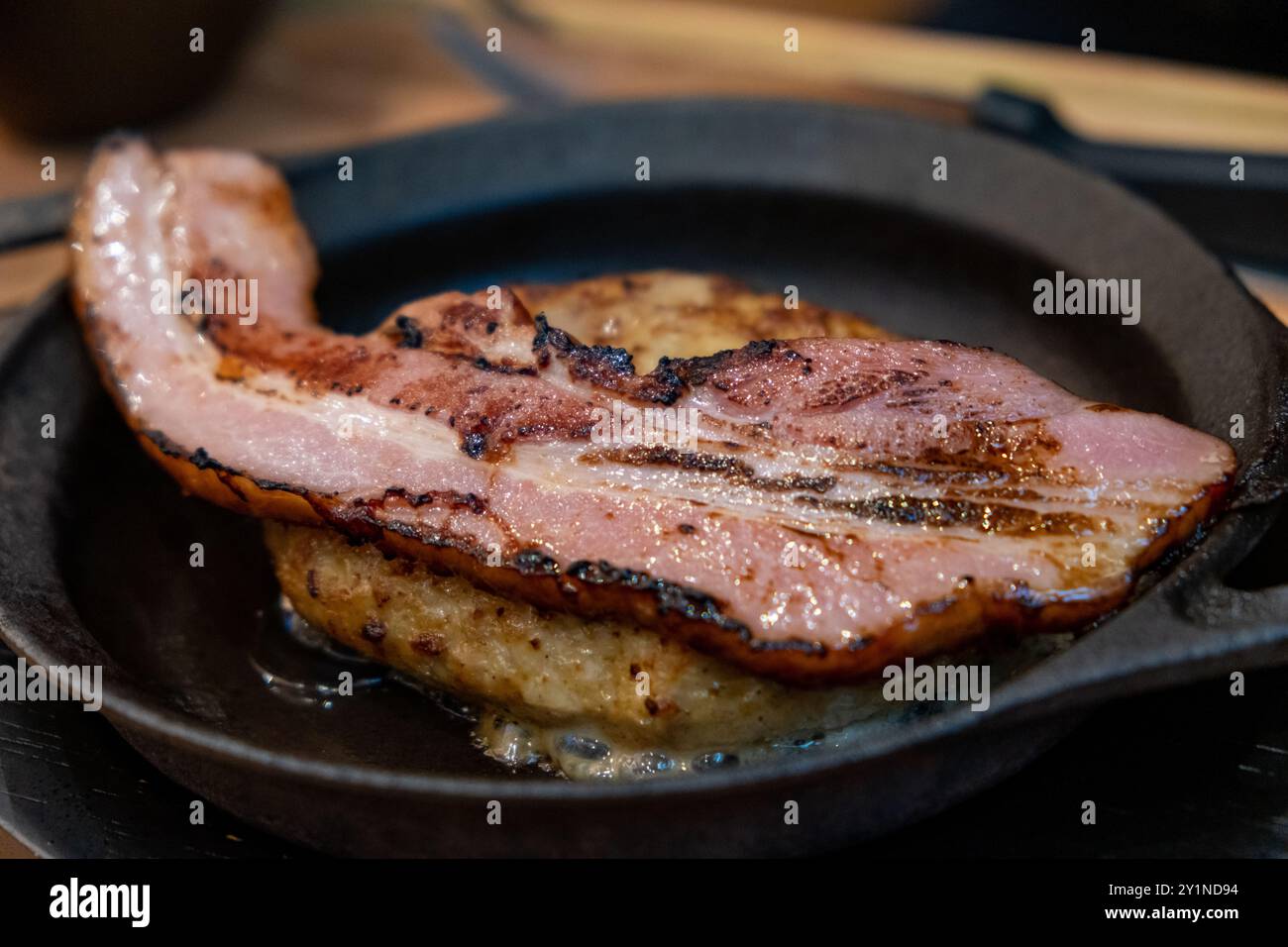 Bistecca di Amburgo su una ciotola di riso, con pancetta tagliata in alto. Cibo giapponese Foto Stock