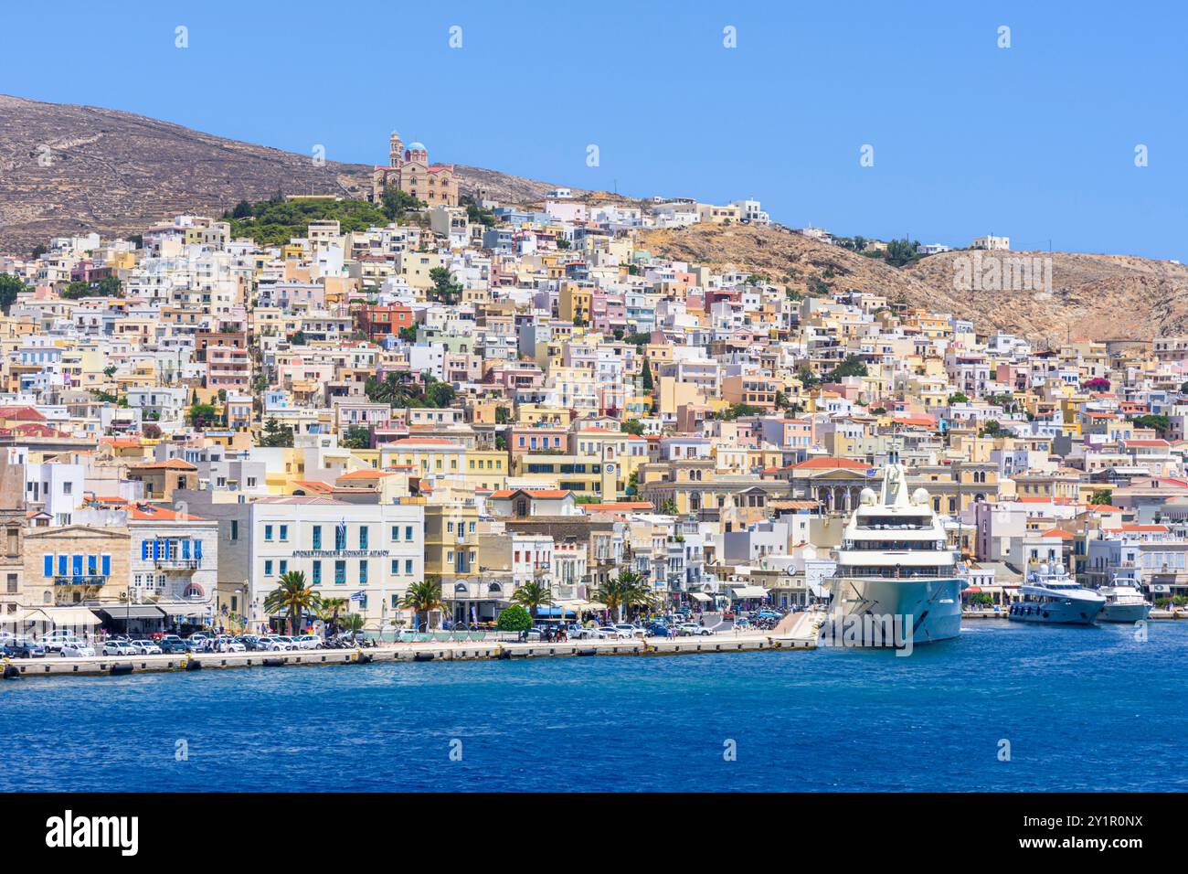 Vista sul lungomare e sulla Chiesa di Anastasi in cima al colle di Vrodado, Ermoupoli, isola di Syros, Cicladi, Grecia Foto Stock
