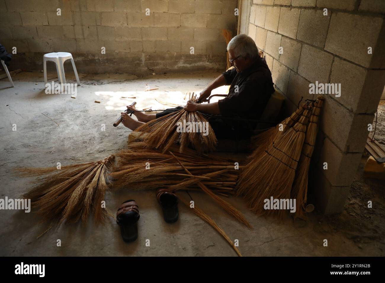 Cisgiordania, Palestina. 27 settembre 2019. Sobhi Jaradat, 57 anni, produce scopa di paglia da quasi 15 anni nel villaggio di Zububa, nel governatorato di Jenin. Per produrre le scope, Jaradat utilizza un tipo speciale di mais, che viene coltivato dagli agricoltori locali dall'inizio di aprile e richiede cure fino alla fine di luglio. I gambi di mais vengono raccolti, puliti dai semi e poi portati all'artigiano che crea le spazzatrici. In Palestina, l'arte di fare scopa con la paglia è stata tramandata da generazioni e conservata da pochi abili artigiani come Sobhi Foto Stock