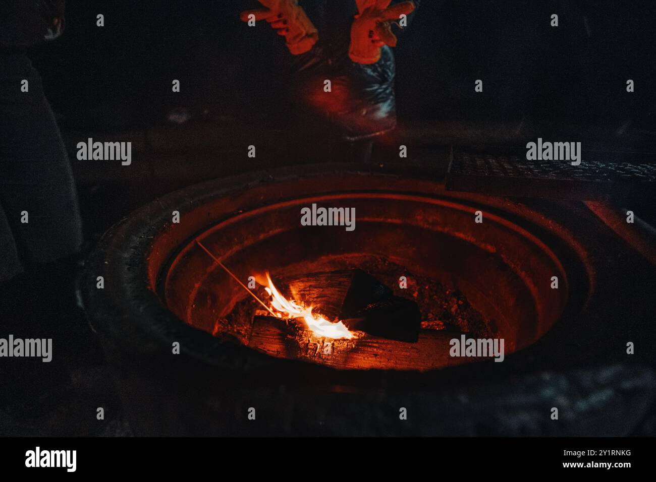 Riscaldare le mani sul fuoco a laavu a Rovaniemi, Lapponia in inverno Foto Stock