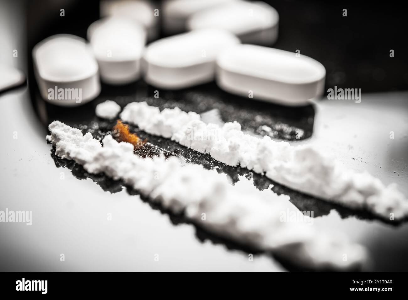 Una visione ravvicinata delle pillole bianche accanto alla polvere di fentanil, sottolineando il rapporto tra farmaci soggetti a prescrizione e la crisi degli oppioidi che colpisce molti Foto Stock