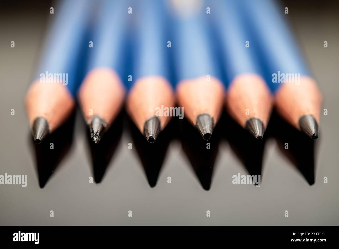 Una vista ravvicinata di matite blu affilate disposte in modo ordinato, che mostrano i loro suggerimenti, perfette per la rappresentazione artistica, i progetti scolastici e il sup dell'ufficio Foto Stock