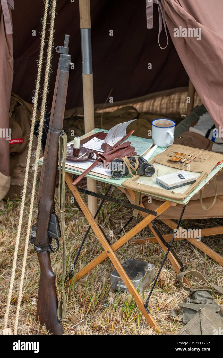 Rievocazione della tenda militare della prima guerra mondiale con fucile e altri oggetti militari su un piccolo tavolo pieghevole della campagna. Foto Stock