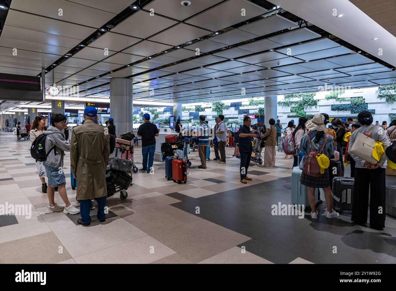 Singapore - 13 giugno 2024 : Efficient Travel: I passeggeri ritirano le loro valigie dal nastro trasportatore dell'aeroporto, pronti per il loro viaggio al Terminal 3, Foto Stock