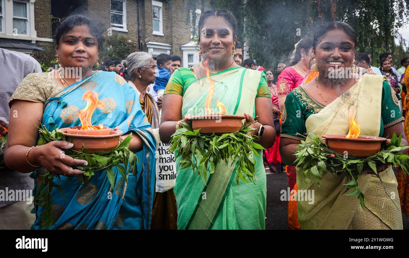 Londra, Regno Unito. 8 settembre 2024. Diverse migliaia di devoti della comunità Tamil prendono parte all'annuale Festival dei carri (Ter) dal tempio di Sivan Kovil per le strade di Lewisham. Le divinità di Ganesha e Lord Shiva sono trasportate in carri decorati. I devoti fanno offerte di latte, incenso bruciato, noci di cocco o frutta. Crediti: Imageplotter/Alamy Live News Foto Stock