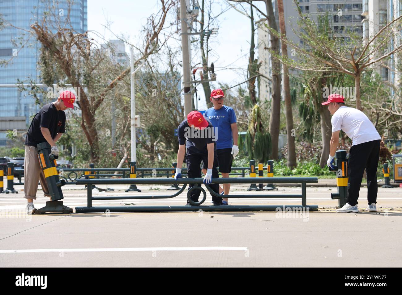 Haikou, la provincia cinese di Hainan. 8 settembre 2024. I volontari sollevano una ringhiera caduta su una strada a Haikou, nella provincia di Hainan, nella Cina meridionale, 8 settembre 2024. Yagi, l'undicesimo tifone dell'anno, sbarcò a Hainan il venerdì pomeriggio. Quando venti e piogge si placarono, Hainan diminuì il suo allarme tifone e avviò rapide operazioni di recupero in tutta la provincia. Crediti: Zhang Liyun/Xinhua/Alamy Live News Foto Stock