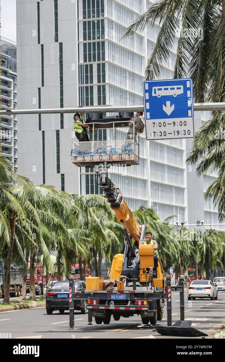 Haikou, la provincia cinese di Hainan. 8 settembre 2024. Un lavoratore ripara i semafori su una strada a Haikou, nella provincia cinese di Hainan, 8 settembre 2024. Yagi, l'undicesimo tifone dell'anno, sbarcò a Hainan il venerdì pomeriggio. Quando venti e piogge si placarono, Hainan diminuì il suo allarme tifone e avviò rapide operazioni di recupero in tutta la provincia. Crediti: Zhang Liyun/Xinhua/Alamy Live News Foto Stock