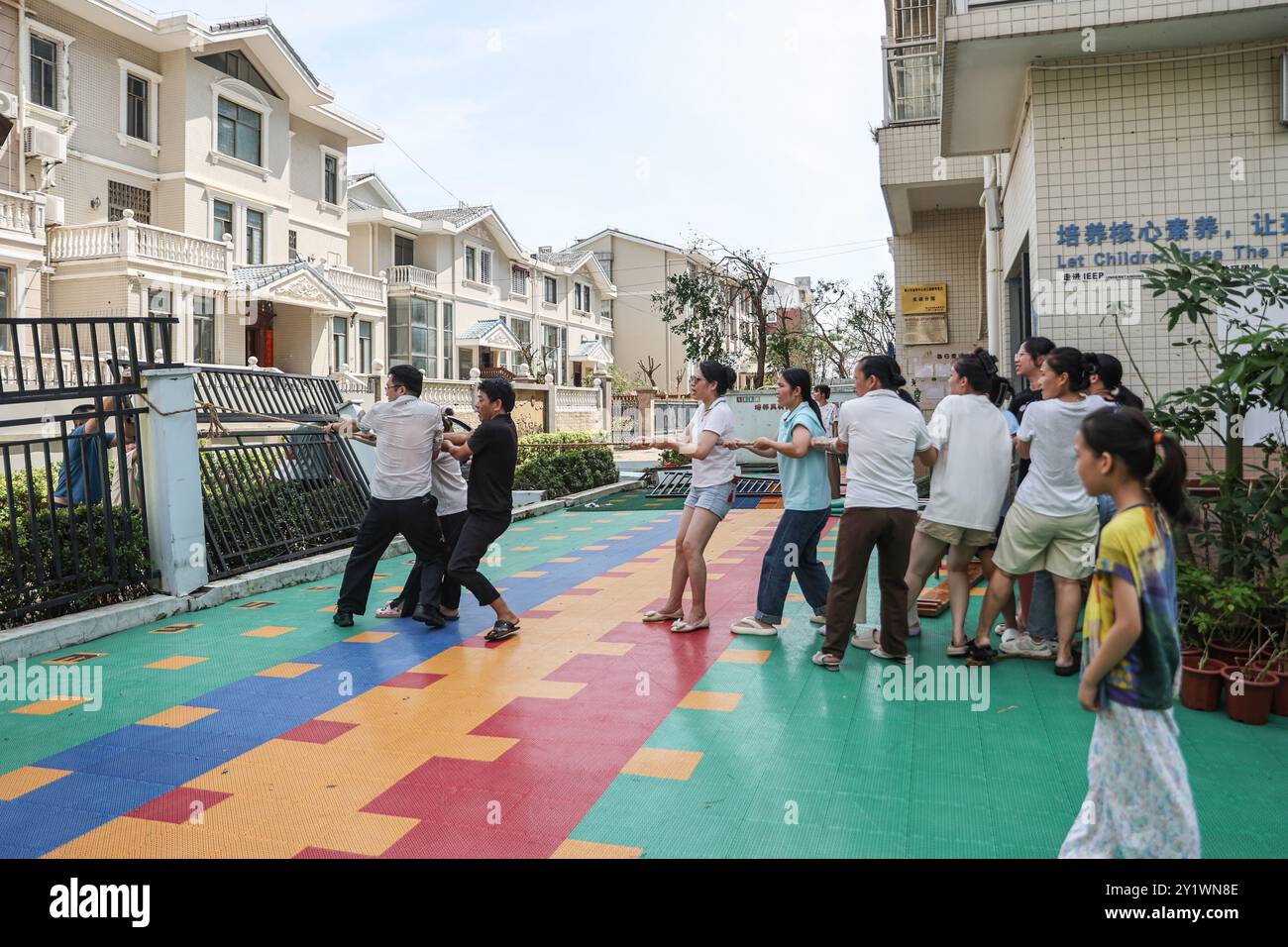 Haikou, la provincia cinese di Hainan. 8 settembre 2024. Gli insegnanti tirano su una recinzione pendente in un asilo di Haikou, nella provincia cinese di Hainan, 8 settembre 2024. Yagi, l'undicesimo tifone dell'anno, sbarcò a Hainan il venerdì pomeriggio. Quando venti e piogge si placarono, Hainan diminuì il suo allarme tifone e avviò rapide operazioni di recupero in tutta la provincia. Crediti: Zhang Liyun/Xinhua/Alamy Live News Foto Stock