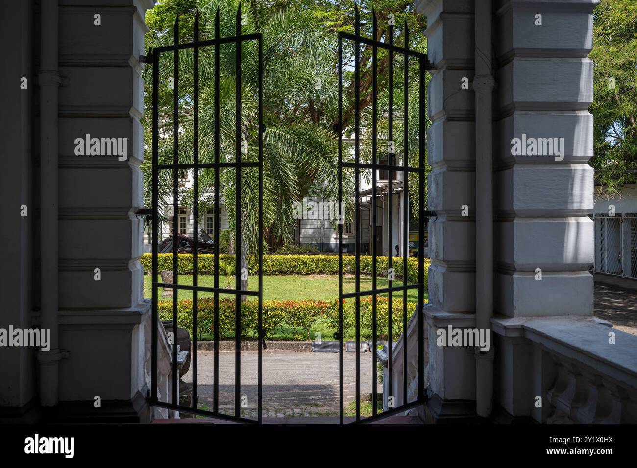 Una foto che guarda attraverso i cancelli che portano ai giardini del Museo Nazionale Colombo in Sri Lanka Foto Stock