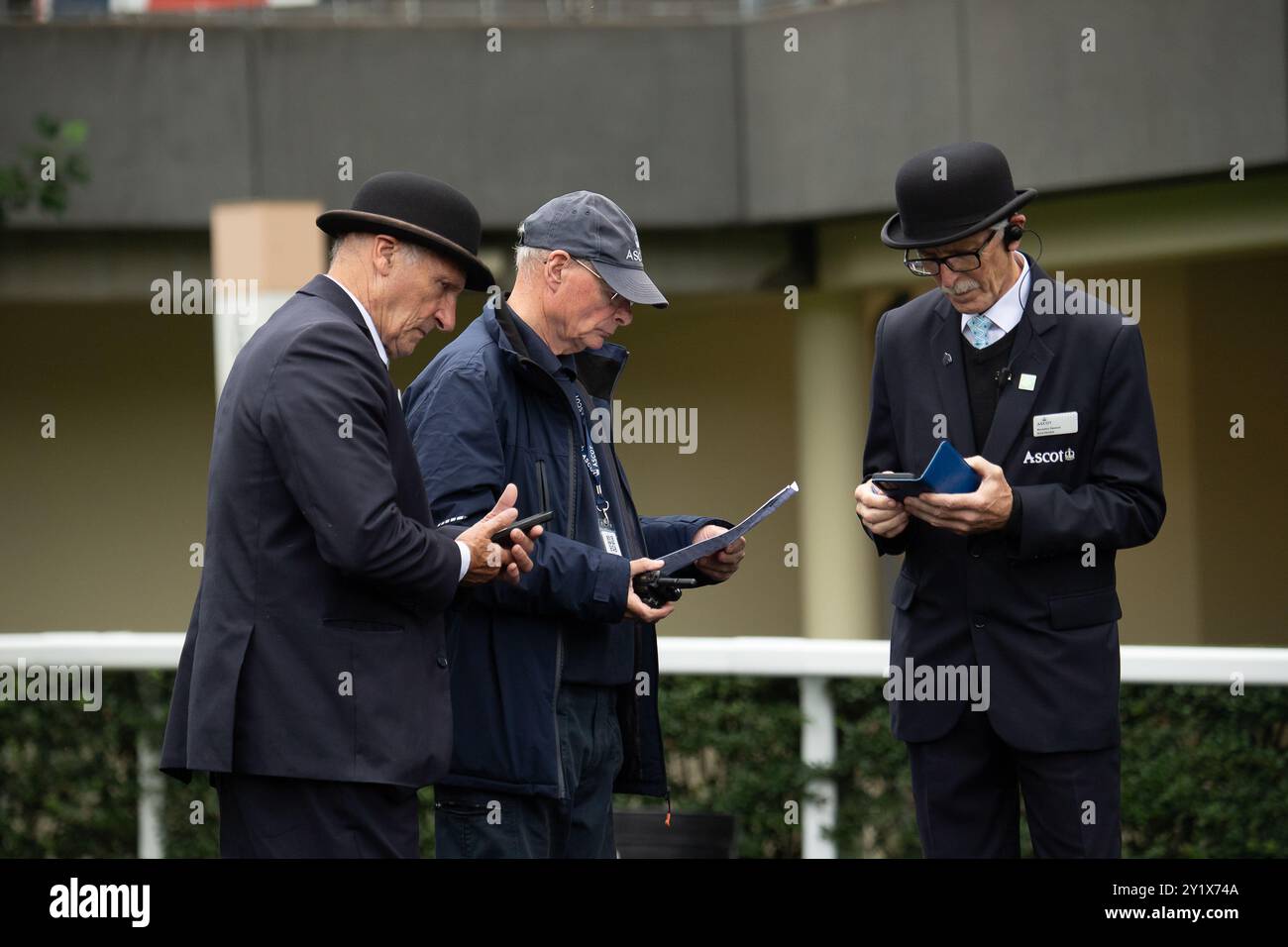 Ascot, Berkshire, Regno Unito. 7 settembre 2024. Secondo giorno del Big Food and drink Festival all'ippodromo di Ascot nel Berkshire. Gli amministratori Ascot guardano la racecard Ascot sul loro cellulare, mentre questo fine settimana l'Ascot Racecourse sta provando utilizzando i fogli di gara invece delle carte gara, e sono accessibili anche tramite telefono cellulare. Crediti: Maureen McLean/Alamy Foto Stock