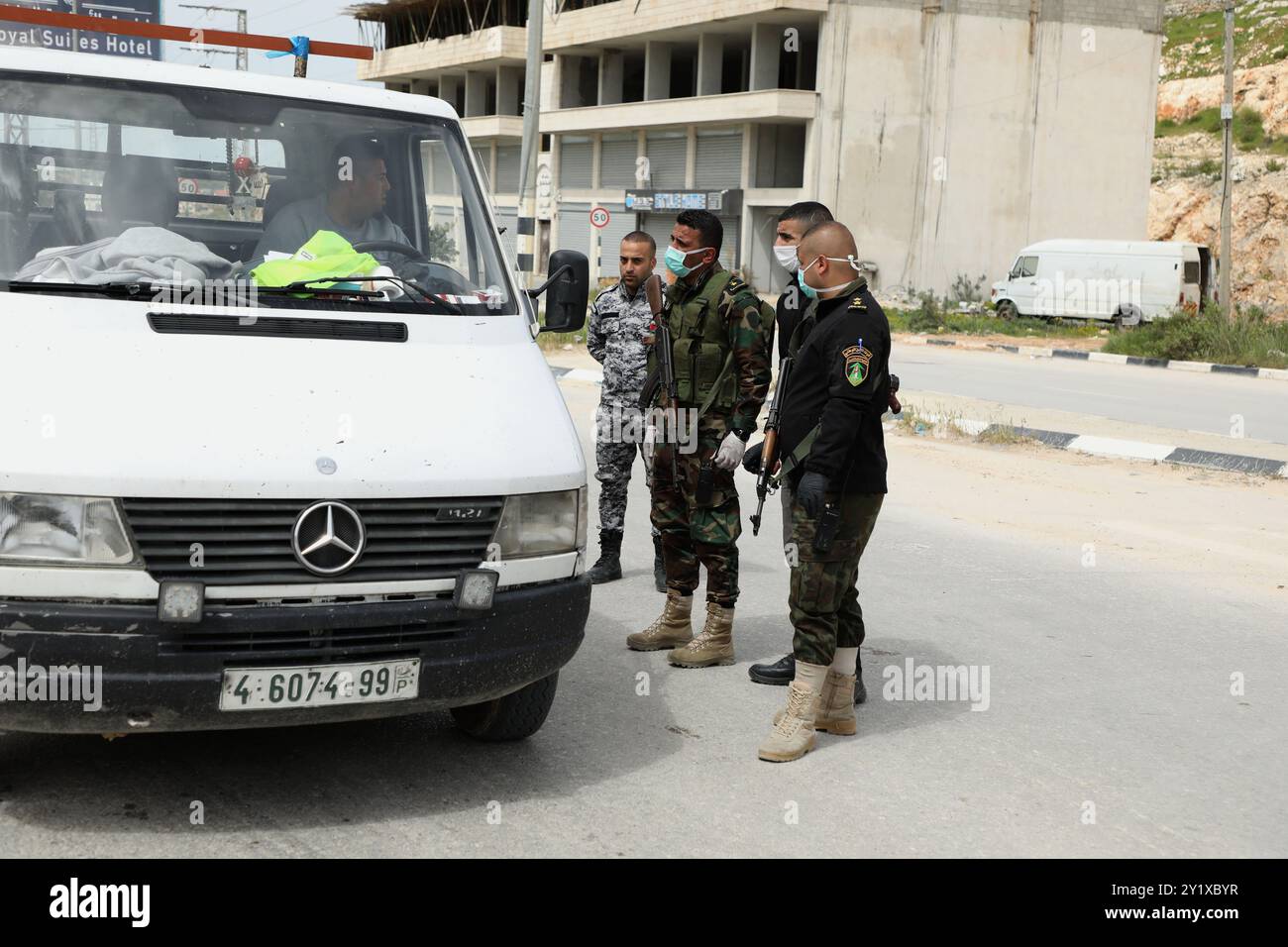 Nablus, Palestina. 23 marzo 2020. I membri delle forze di sicurezza nazionali palestinesi effettuano controlli nella città di Nablus per far rispettare l’attuazione di nuove misure restrittive contro la diffusione del coronavirus in Cisgiordania. Domenica il primo ministro palestinese ha ordinato un divieto di due settimane su tutti i movimenti non essenziali per contenere la diffusione del COVID-19, mentre il numero di casi confermati in Cisgiordania è salito ad almeno 57 Foto Stock