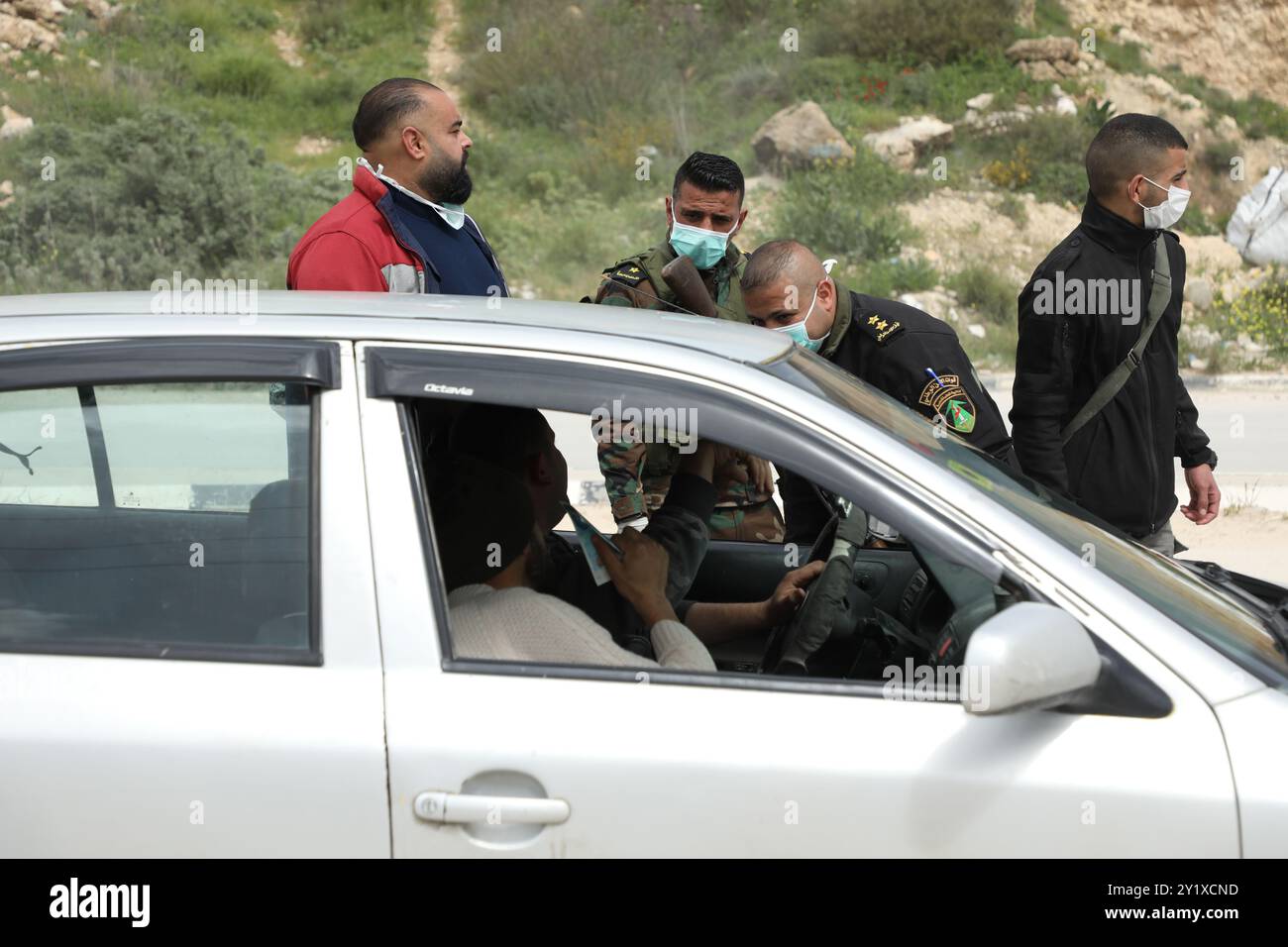 Nablus, Palestina. 23 marzo 2020. I membri delle forze di sicurezza nazionali palestinesi effettuano controlli nella città di Nablus per far rispettare l’attuazione di nuove misure restrittive contro la diffusione del coronavirus in Cisgiordania. Domenica il primo ministro palestinese ha ordinato un divieto di due settimane su tutti i movimenti non essenziali per contenere la diffusione del COVID-19, mentre il numero di casi confermati in Cisgiordania è salito ad almeno 57 Foto Stock