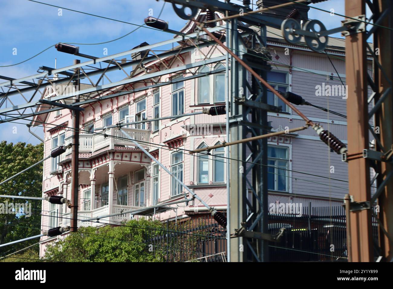 Vecchio edificio rosa con binari ferroviari vicino alla stazione ferroviaria centrale di Helsinki, Finlandia, agosto 2024 Foto Stock