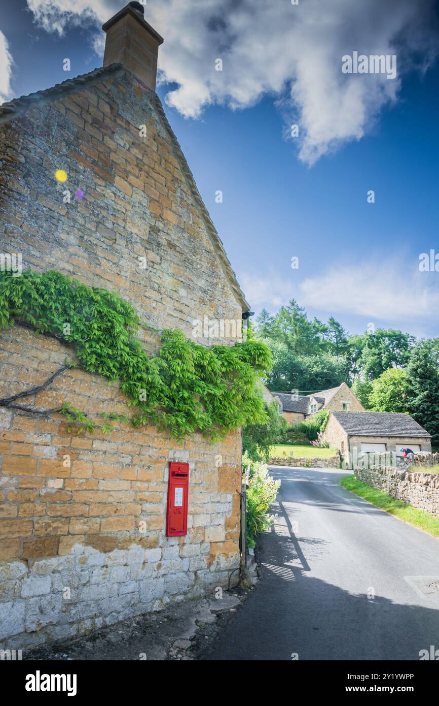 Cassetta delle lettere rossa sul muro della casa del villaggio Foto Stock