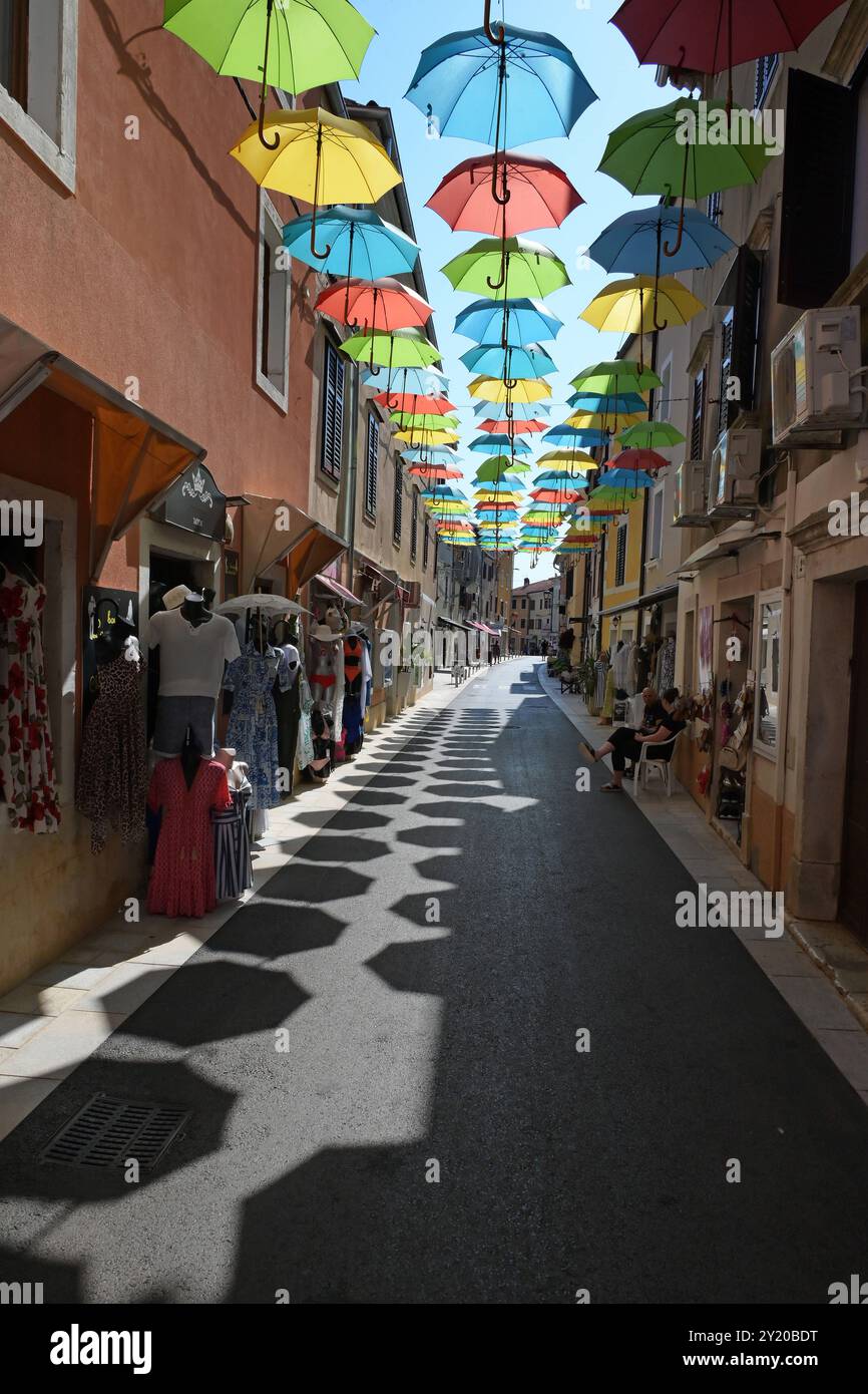 Urlaub mit Margot Stadlmann in Porec / Kroatien, AM 29.08.2024. DAS Bild zeigt die Haupteinkaufsstraße von Novigrad mit bunten, aufgespannten Regenschirmen 2024 - Urlaub mit Margot Stadlmann in Porec / Kroatien, am 29.08.2024. *** Vacanza con Margot Stadlmann a Porec Croazia, il 29 08 2024 l'immagine mostra la principale via dello shopping di Novigrad con ombrelli colorati e aperti 2024 vacanza con Margot Stadlmann a Porec Croazia, il 29 08 2024 Foto Stock