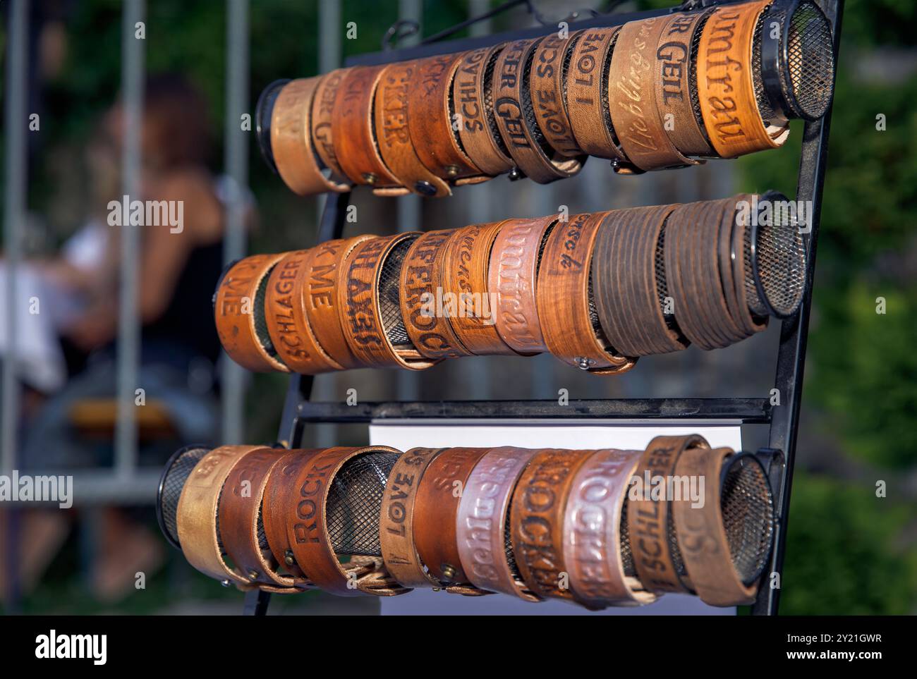 Braccialetti in pelle esposti su piedistalli, incisi su misura, stile vintage, in un mercato all'aperto, concetto di moda degli accessori Foto Stock