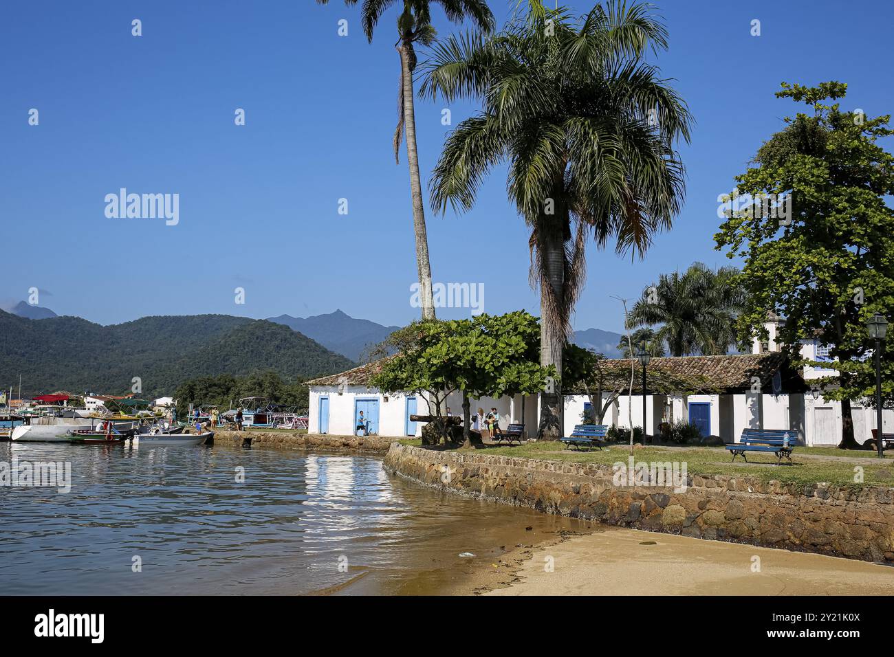 Vista sul lungomare della città storica di Paraty con edifici coloniali, alberi, mare e montagne della foresta atlantica, Brasile, patrimonio dell'umanità dell'UNESCO, South Ame Foto Stock