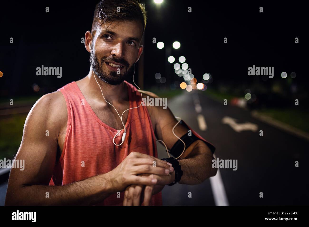 Ritratto del corridore maschile durante l'allenamento notturno in città. Foto Stock