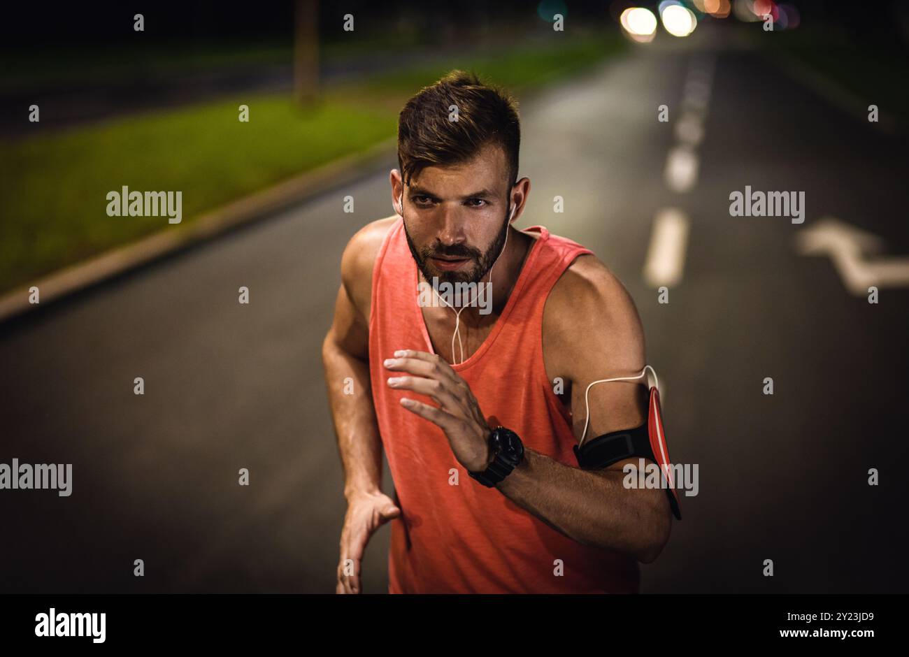Uomo che corre per la strada della città di notte. Foto Stock