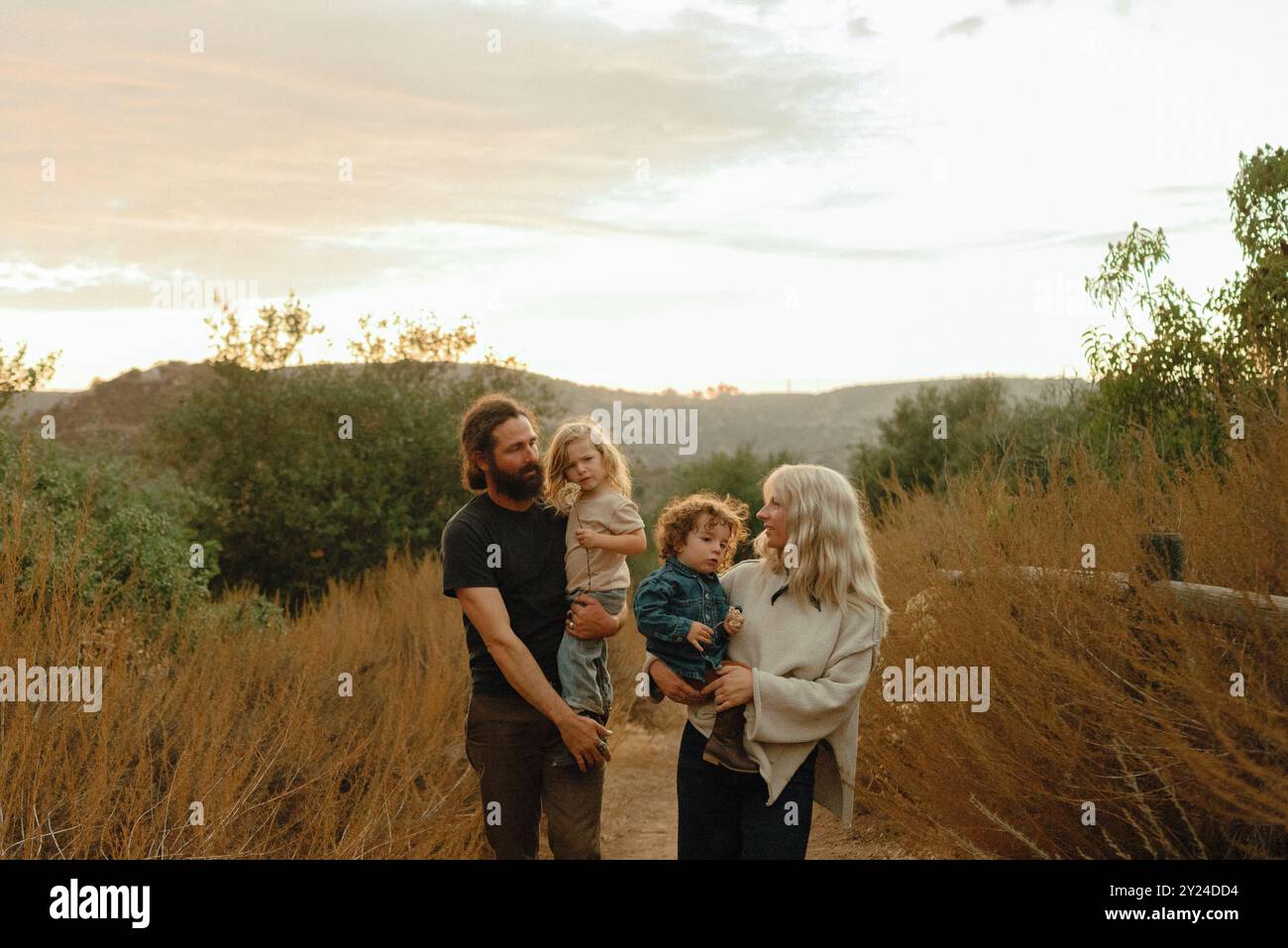 Una famiglia di quattro persone percorre il sentiero naturale al tramonto Foto Stock