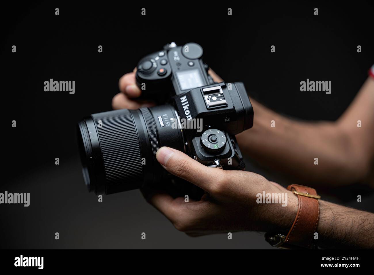 Uomini che tengono in mano la macchina fotografica Nikon Z6 III. messa a fuoco selettiva Foto Stock