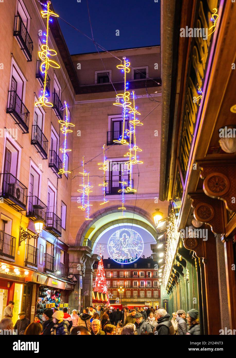 Le decorazioni natalizie illuminano Calle de la Sal con luci al calar della notte. Un passaggio ad arco sullo sfondo conduce a Plaza Mayor. Madrid, Spagna. Foto Stock