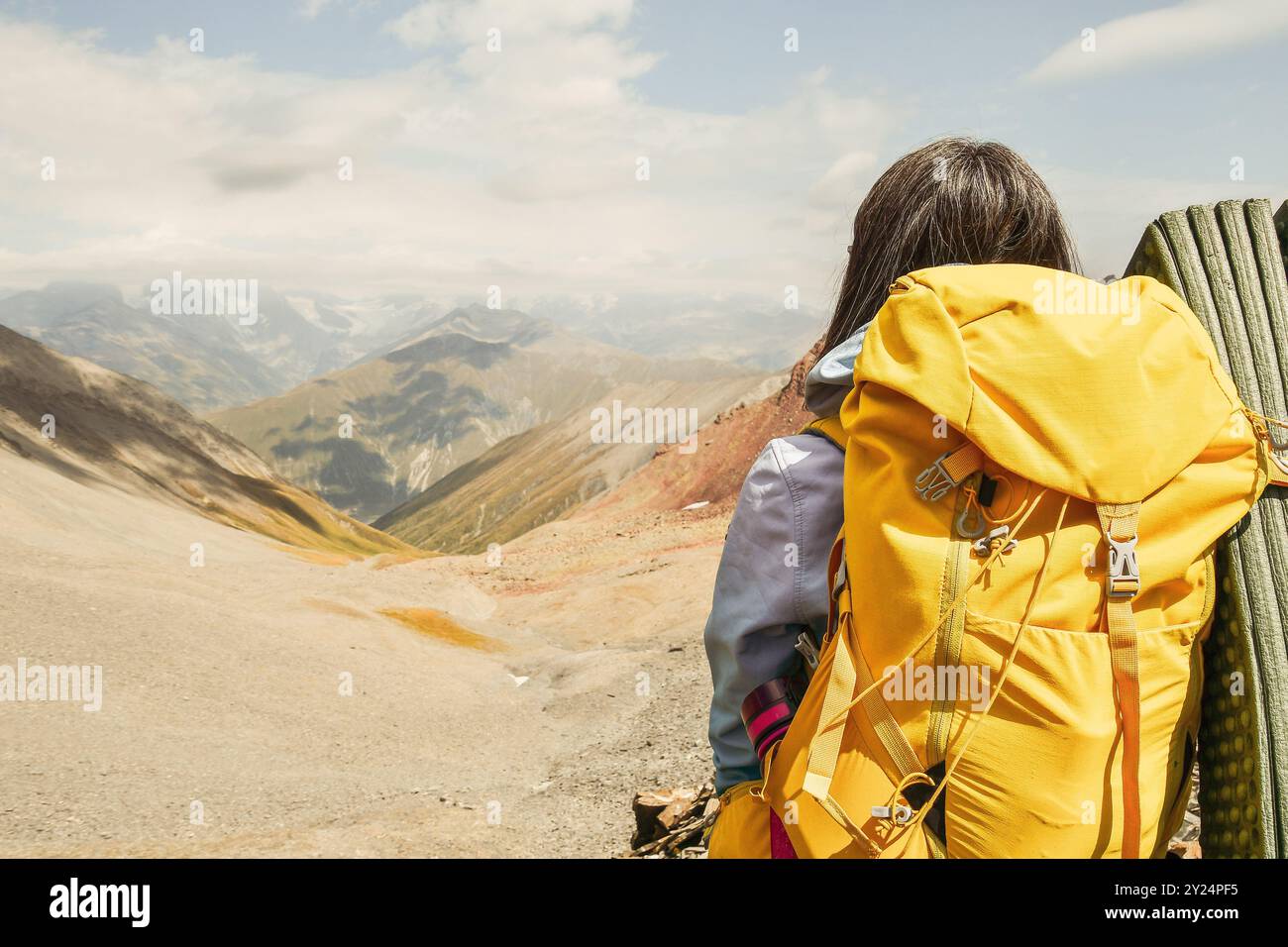 Vista ravvicinata dal retro donna irriconoscibile con elegante zaino giallo con fiasca che fuoriesce dalla tasca laterale. Copia banner spazio di copia. W Foto Stock