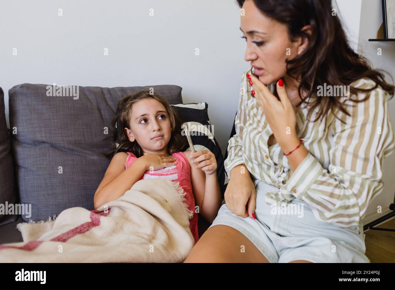 Assicurazione sanitaria di famiglia : ragazza malata con febbre e una madre preoccupata Foto Stock