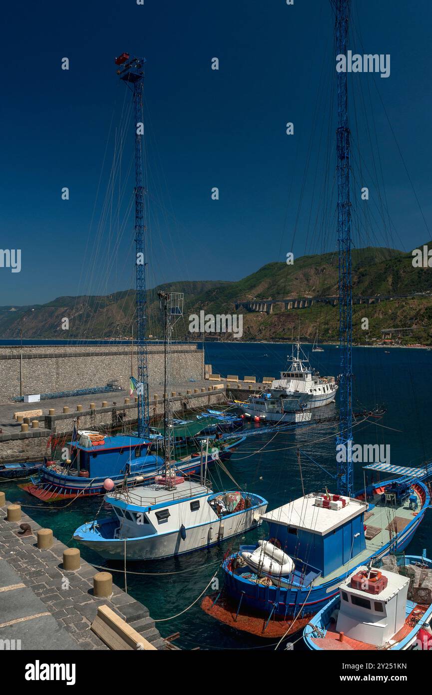 Passarelle, tradizionali pescherecci di pesce spada nel porto di Scilla, una cittadina della Calabria, Italia, che si affaccia sul Mar Tirreno e sullo stretto di Messina. La zona ha una tradizione di pesca del pesce spada che risale a più di 2.000 anni fa. Ogni peschereccio di pesce spada ha una passarella, un lungo ponte di ferro che si estende a metri dalla parte anteriore. Foto Stock