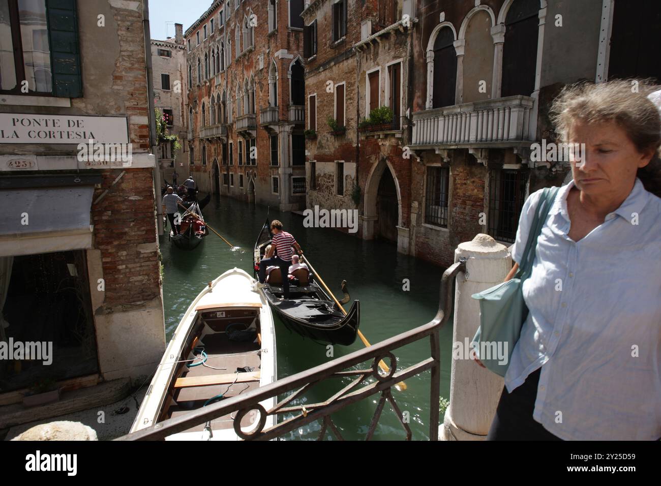 Venezia, Italia. 9 settembre 2024. Una passeggiata locale attraversa il Ponte de la Cortesia mentre i turisti fanno un giro in gondole il 9 settembre 2024 a Venezia, Italia. I turisti e gli abitanti delle città d'Italia, tra cui Venezia, Milano e Roma, hanno dovuto subire ritardi e cancellazioni lunedì 9 settembre, a causa di uno sciopero nazionale di otto ore che ha colpito i servizi di trasporto pubblico locale. (Foto di Paulo Amorim/Sipa USA) credito: SIPA USA/Alamy Live News Foto Stock