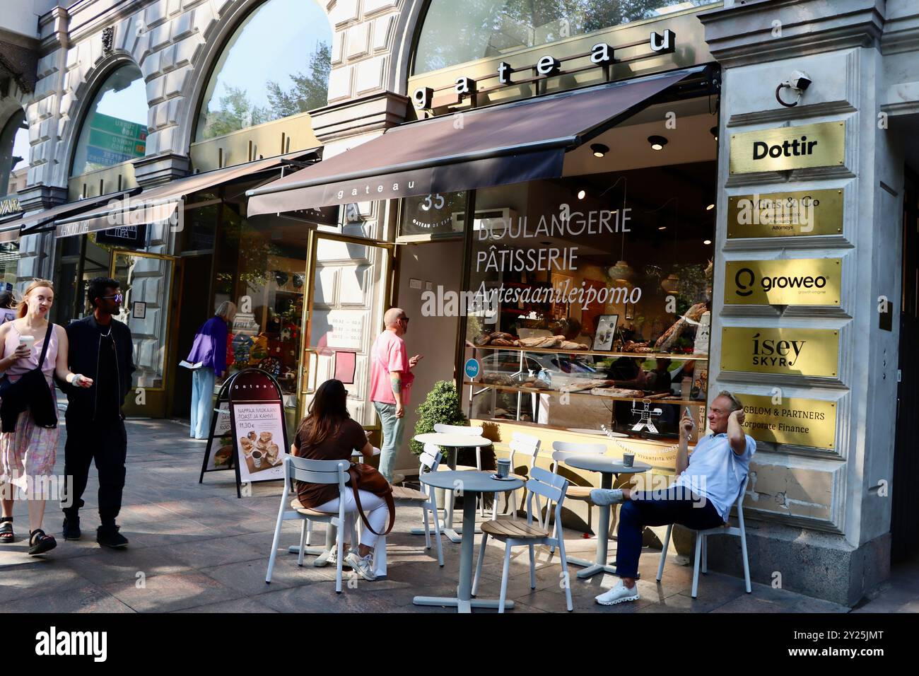 Posti a sedere sul marciapiede presso Boulangerie Gateau in via Pohjois Esplanadi nel centro di Helsinki, Finlandia Foto Stock