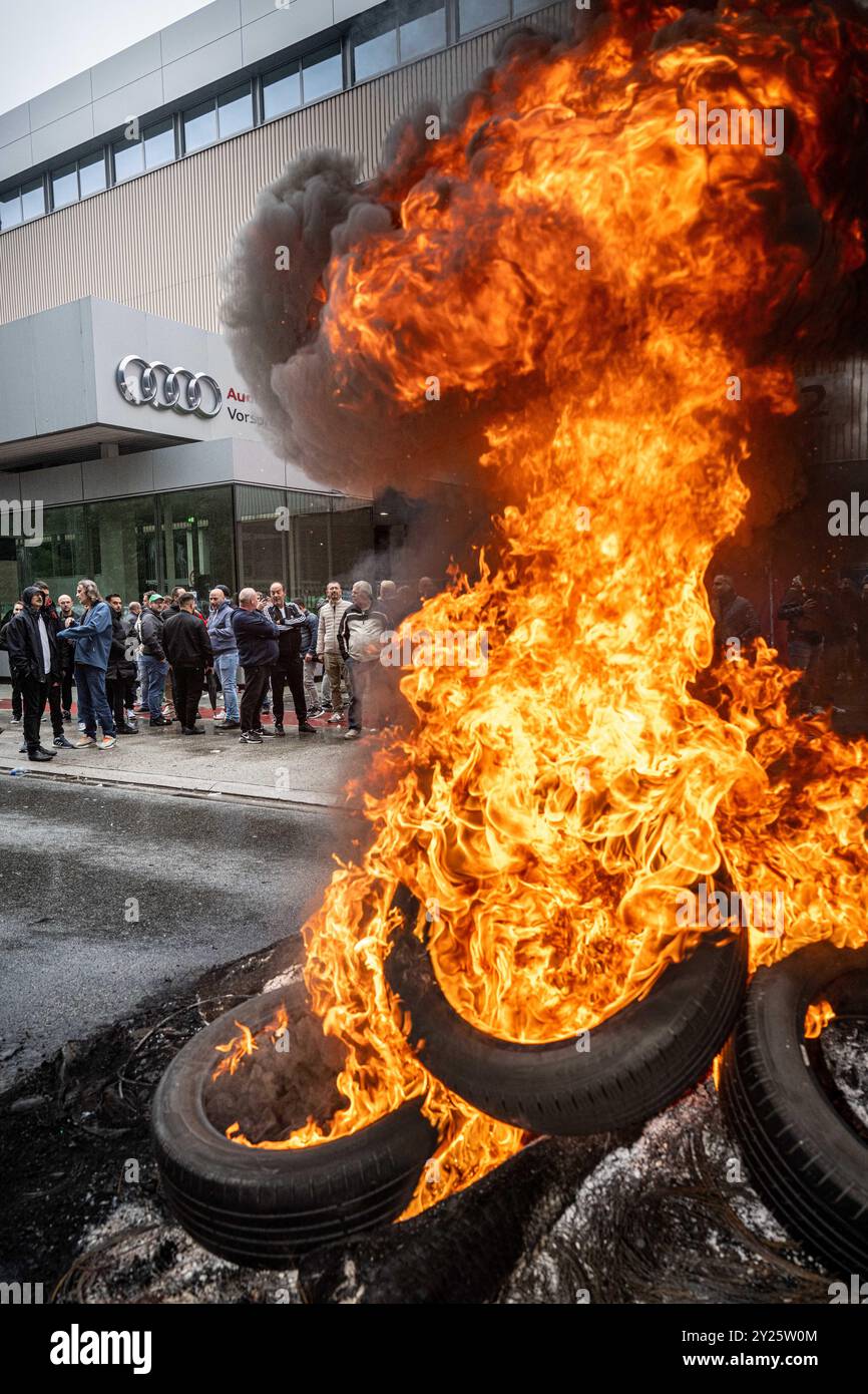 Bruxelles, Belgio. 9 settembre 2024. Gli incendi sono stati visti bruciare fuori dallo stabilimento Audi Brussels, nella foresta di Vorst, Bruxelles, lunedì 9 settembre 2024. La direzione ha annunciato ieri sera che lo stabilimento rimarrà chiuso fino a quando i lavoratori non avranno accettato di riprendere la produzione e consegnare le auto ai concessionari. I sindacati hanno confiscato la scorsa settimana le chiavi di circa 200 auto finché non avranno chiarezza sul futuro dello stabilimento. BELGA FOTO JONAS ROOSENS credito: Belga News Agency/Alamy Live News Foto Stock
