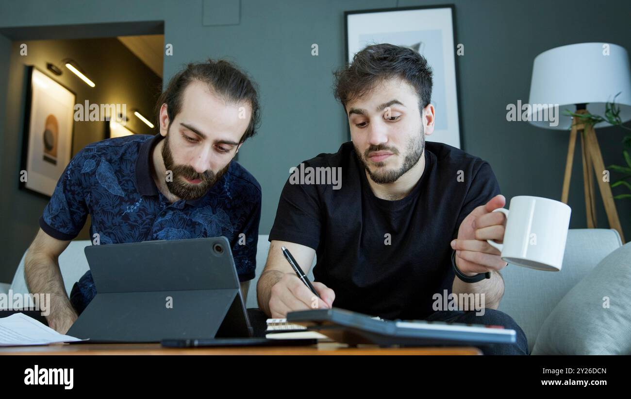 Due uomini sono seduti su un divano, lavorano ad una discussione sul progetto. Foto Stock