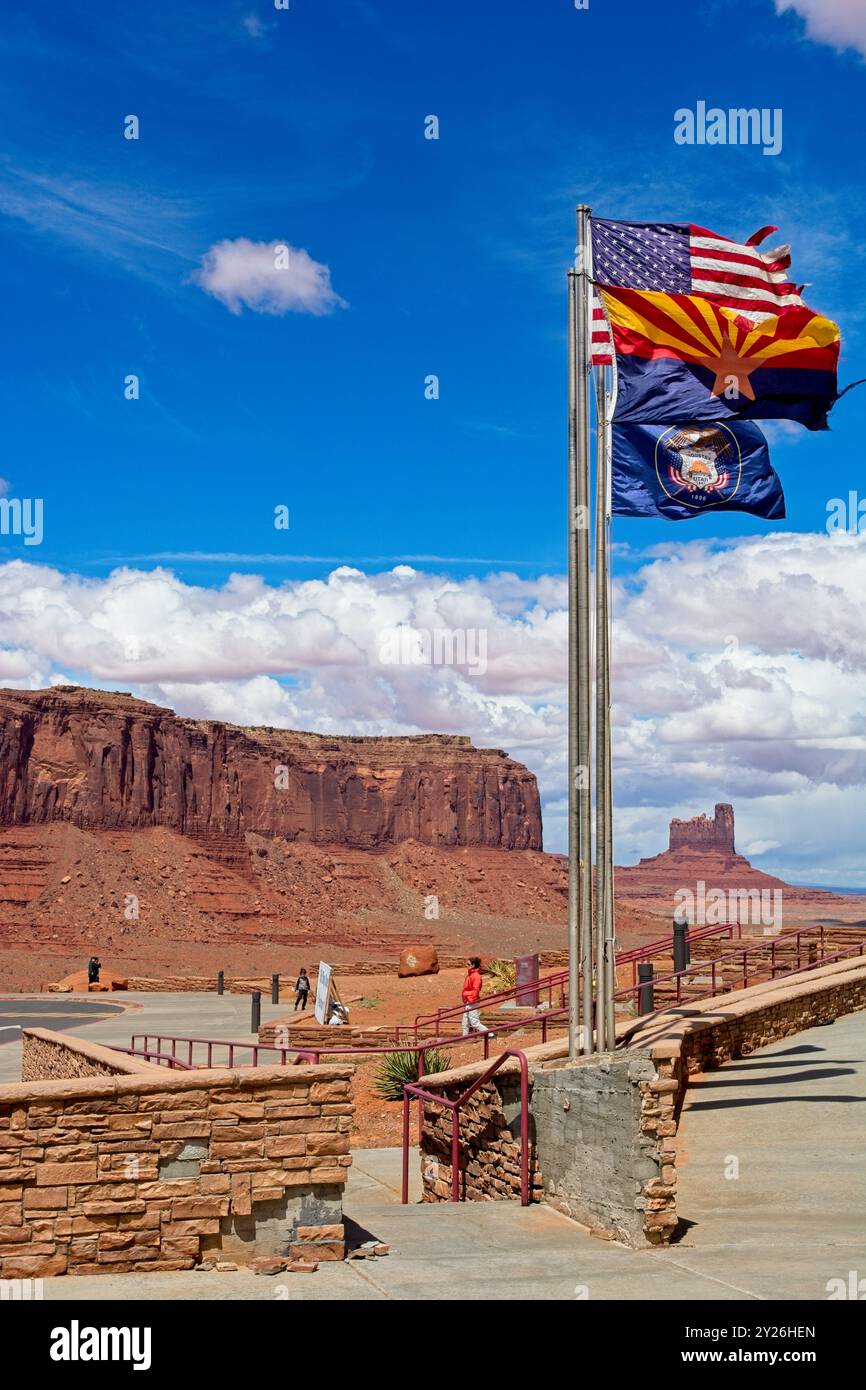 Bandiera americana che sventola in brezza accanto alle bandiere dello Utah e dell'Arizona sulla terrazza all'esterno del centro visitatori della Monument Valley -- Arizona, aprile 2024 Foto Stock