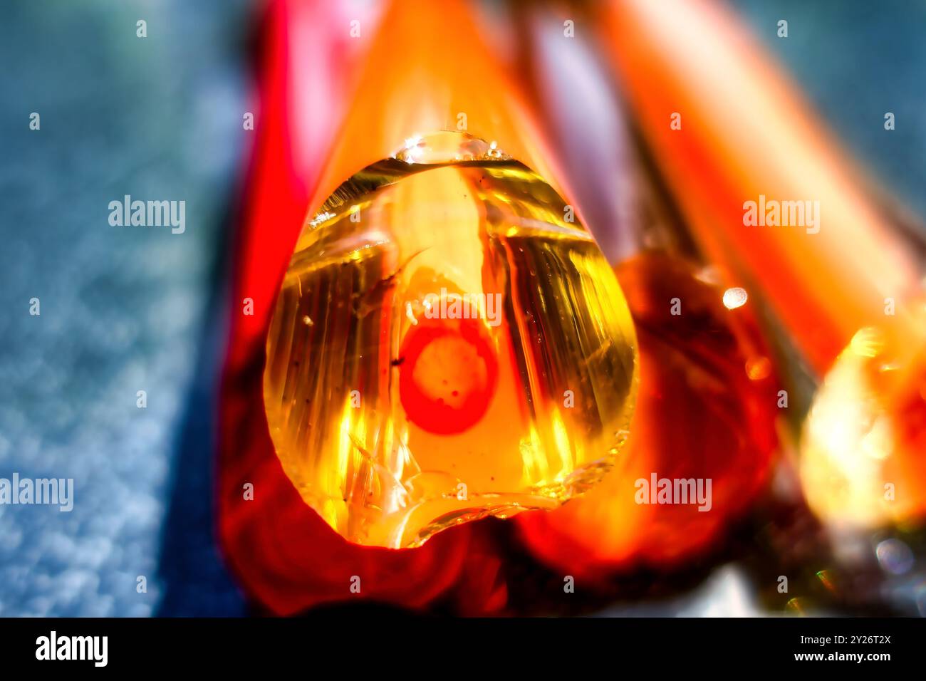 Vista ravvicinata intenzionalmente sfocata di un'asta di vetro colorata con nucleo e rivestimento. immagine macro Foto Stock